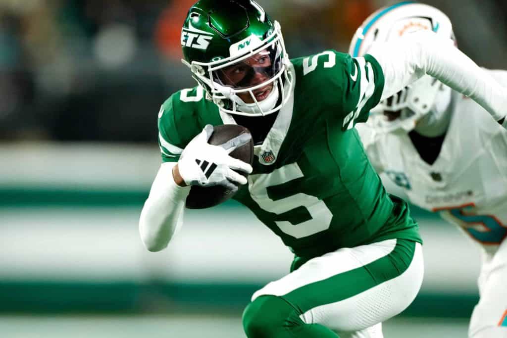 New York Jets wide receiver Garrett Wilson (5) runs with the ball past Miami Dolphins cornerback Jalen Ramsey (5), Sunday