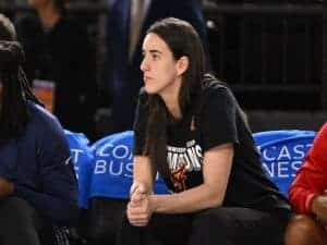 Indiana Fever guard Caitlin Clark looks on from the bench against the Washington Mystics .
