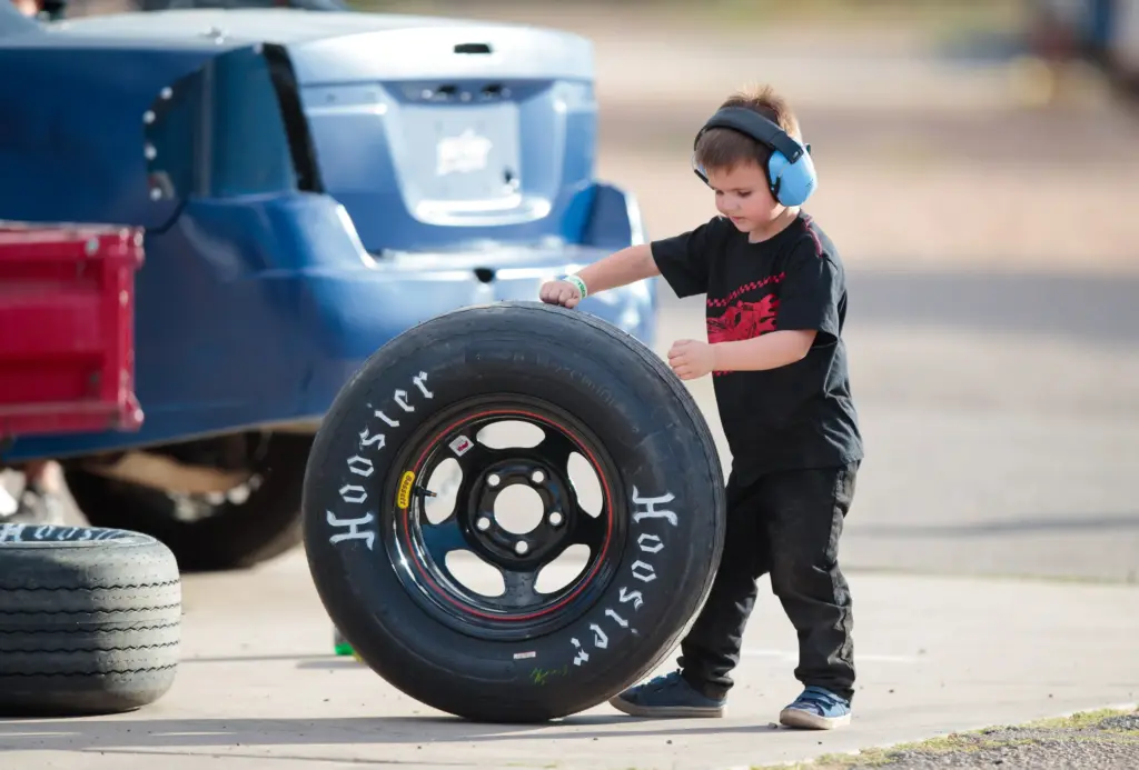 May 11, 2019; Tucson, AZ, USA; A young fan pushes a Hoosier tire in the pit area of Tucson Speedway. Mandatory Credit: Mark J. Rebilas-Imagn Images