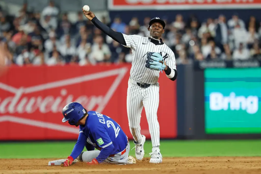 Oct 8, 2025; Bronx, New York, USA; New York Yankees second baseman Jazz Chisholm Jr. (13) forces out Toronto Blue Jays third baseman Ernie Clement (22) and tries to turn a double play during the eighth inning during game four of the ALDS round for the 2025 MLB playoffs at Yankee Stadium. Mandatory Credit: Vincent Carchietta-Imagn Images