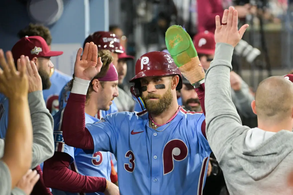 Oct 8, 2025; Los Angeles, California, USA; Philadelphia Phillies first baseman Bryce Harper (3) celebrates in the dugout after scoring on a Los Angeles Dodgers throwing error during the fourth inning during game three of the NLDS round for the 2025 MLB playoffs at Dodger Stadium. Mandatory Credit: Jayne Kamin-Oncea-Imagn Images
