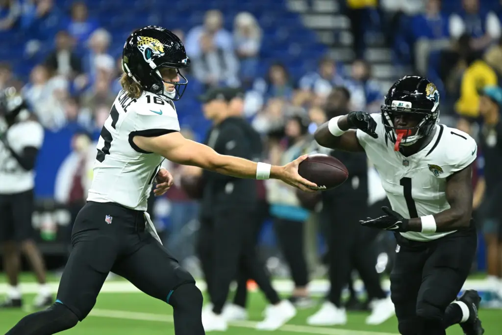 Dec 28, 2025; Indianapolis, Indiana, USA; Jacksonville Jaguars quarterback Trevor Lawrence (16) and running back Travis Etienne Jr. (1) warm up before a game against the Indianapolis Colts during the first half at Lucas Oil Stadium. Mandatory Credit: Robert Goddin-Imagn Images