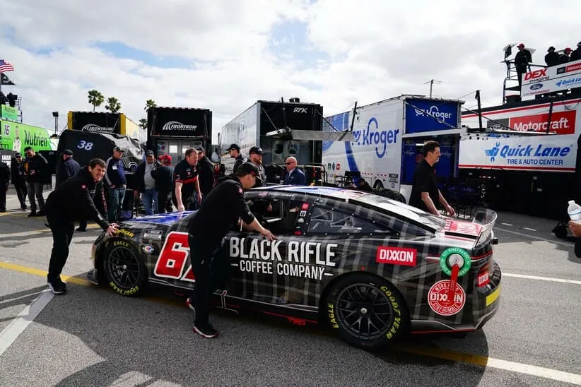 Feb 18, 2023; Daytona Beach, Florida, USA; Crew members push the NASCAR Cup Series driver Travis Pastrana (67) car back to his garage stall preparing for practice for the Daytona 500 at Daytona International Speedway