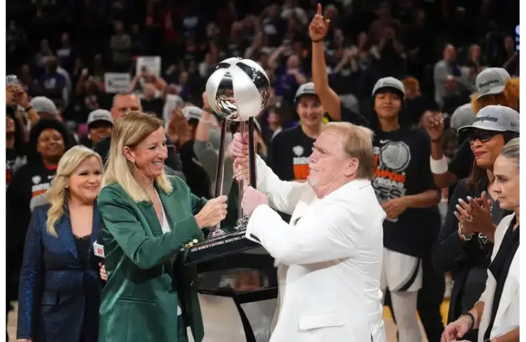WNBA commissioner Cathy Englebert hands the championship trophy to Las Vegas Aces owner Mark Davis