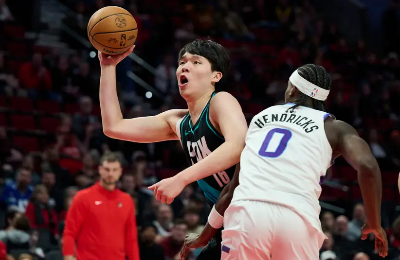 Portland trail blazers Center Yang Hansen (16) drives past Jazz F Taylor Hendricks (0).
