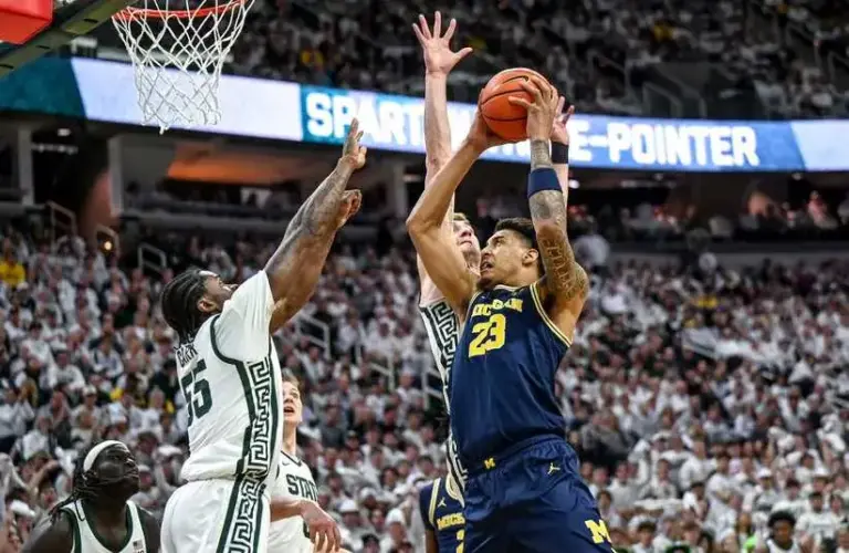 Michigan State's Coen Carr, left, and Carson Cooper, center, guard Michigan's Yaxel Lendeborg during the first half.