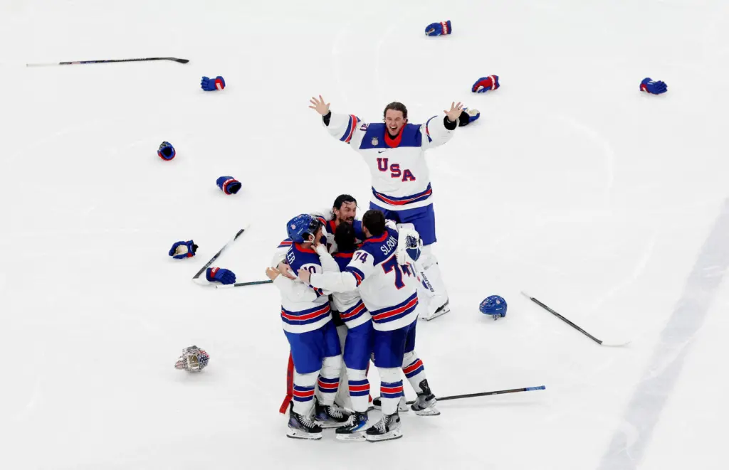 Feb 22, 2026; Milan, Italy; United States players celebrate after defeating Canada in the men's ice hockey gold medal game during the Milano Cortina 2026 Olympic Winter Games at Milano Santa Giulia Ice Hockey Arena.