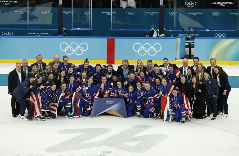 Feb 19, 2026; Milan, Italy; United States players, coaches and staff celebrate with their gold medals after defeating Canada in the women's ice hockey gold medal game during the Milano Cortina 2026 Olympic Winter Games at Milano Santa Giulia Ice Hockey Arena.