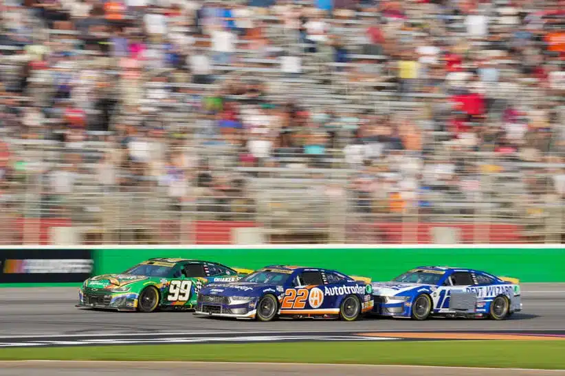 Sep 8, 2024; Hampton, Georgia, USA; NASCAR Cup Series driver Daniel Suarez (99), NASCAR Cup Series driver Joey Logano (22), and NASCAR Cup Series driver Ryan Blaney (12) fight for position along the stretch in the final laps at Atlanta Motor Speedway.