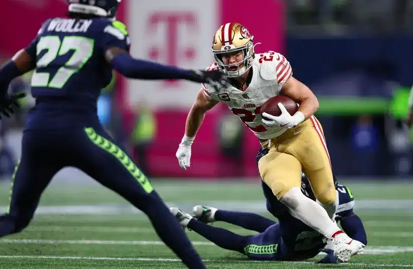 San Francisco 49ers running back Christian McCaffrey (23) carries the ball as Seattle Seahawks cornerback Devon Witherspoon (21)