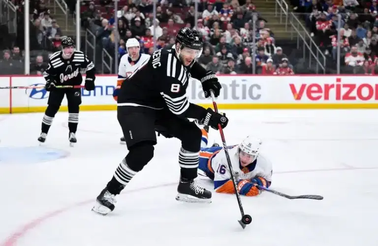 New Jersey Devils defenseman Johnathan Kovacevic (8) controls the puck against New York Islanders center Marc Gatcomb (16)