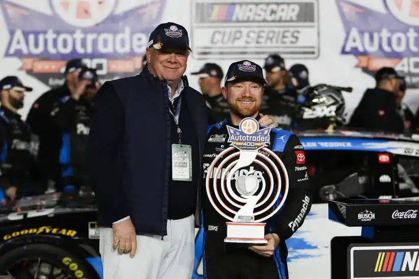 Feb 22, 2026; Hampton, Georgia, USA; President of Cox Automotive Steve Rowley and NASCAR Cup Series driver Tyler Reddick stands with the trophy at EchoPark Speedway.