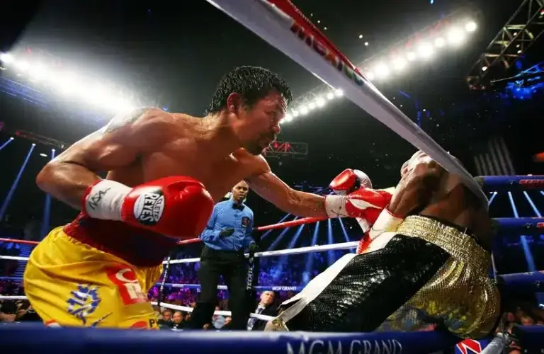 Manny Pacquiao (left) punches Floyd Mayweather against the ropes during their boxing bout at the MGM Grand Garden Arena