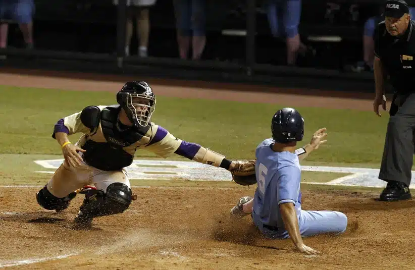 Jun 5, 2011; Chapel Hill, NC, USA; North Carolina catcher Jacob Stallings (5) slides safely into home as James Madison catcher Jake Lowery (3) tries to make the tag during the 8th inning of the Chapel Hill regional of the 2011 NCAA baseball tournament at Boshamer Stadium.