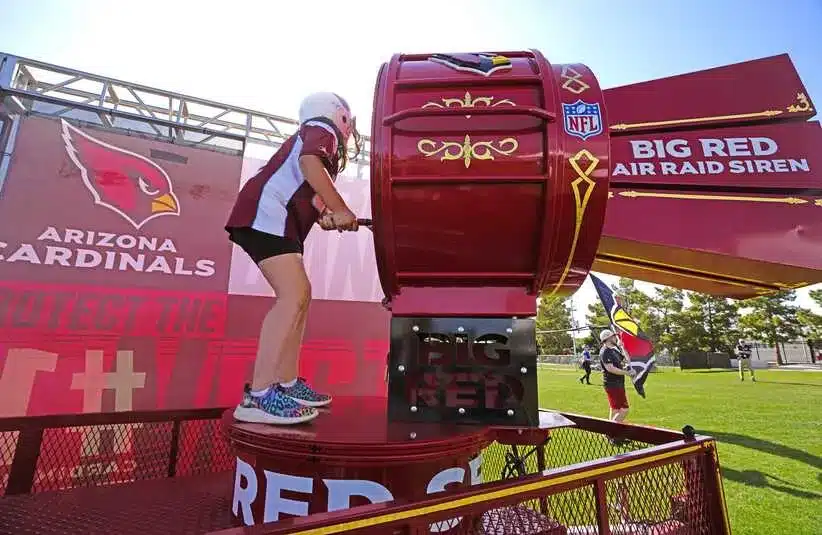 Arizona Cardinals fan Mia Nevarez sounds the siren during a Cardinals draft party outside State Farm Stadium