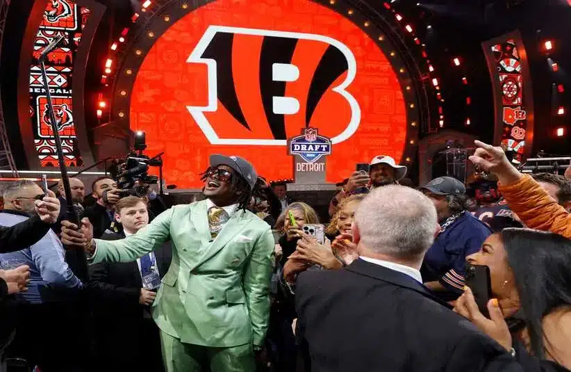 Dallas Turner, a linebacker from the University of Alabama, uses a selfie stick to pose with Vikings fans. (Bengals Logo In Background)
