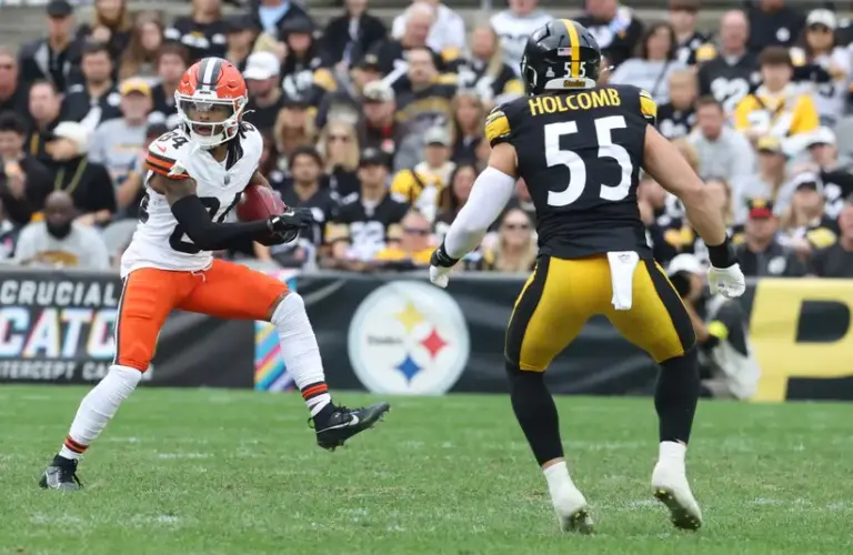 Gage Larvadain (84) of the Cleveland Browns runs after a catch as Cole Holcomb (55) of the Pittsburgh Steelers pursues during the third quarter at Acrisure Stadium.