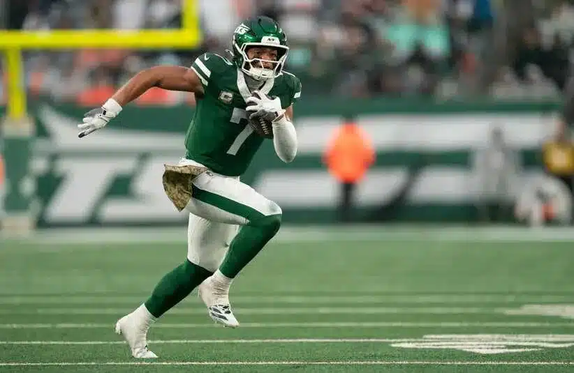 Justin Fields is running for first down at a Jets game.