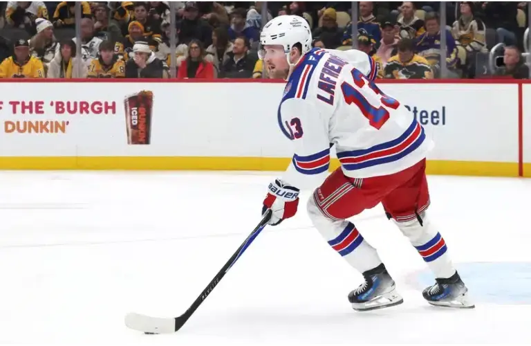 Alexis Lafrenière moves the puck against the Penguins