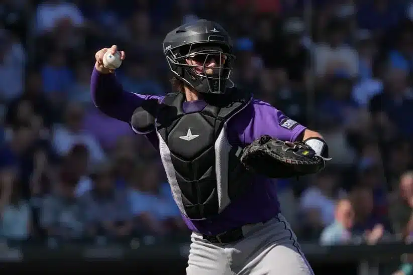 Feb 25, 2026; Mesa, Arizona, USA; Colorado Rockies catcher Hunter Goodman (15) makes the play for an out against the Chicago Cubs in the first inning at Sloan Park.