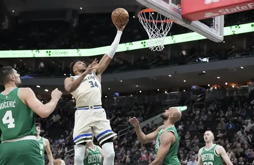 Milwaukee Bucks forward Giannis Antetokounmpo (34) lays up a shot against Boston Celtics guard Derrick White (9)