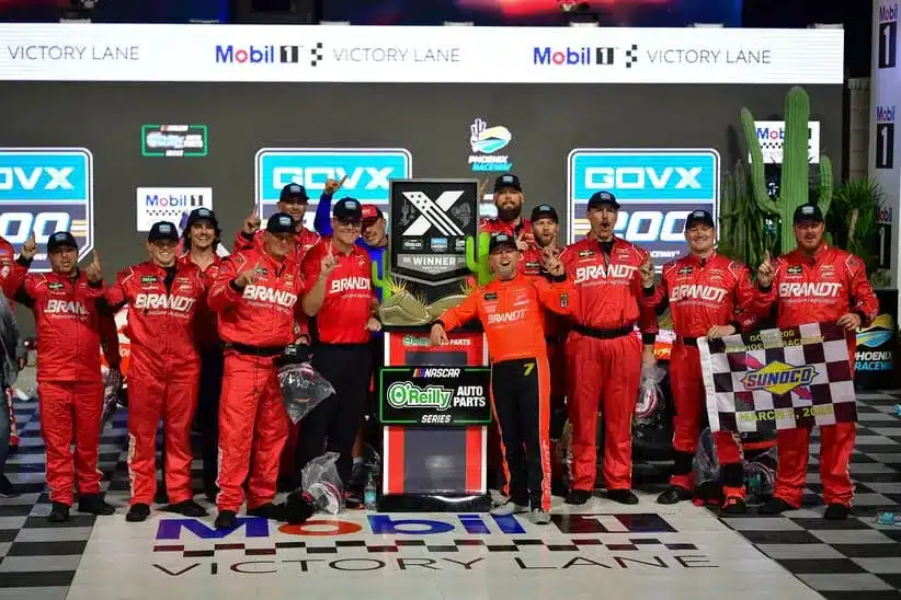 Mar 7, 2026; Avondale, Arizona, USA; JR Motorsports driver Justin Allgaier (7) and crew pose for photos following his victory of the GOVX 200 at Phoenix Raceway.