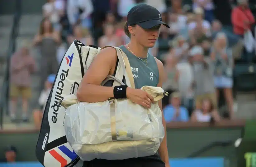 Swiatek carrying her bag out of the court