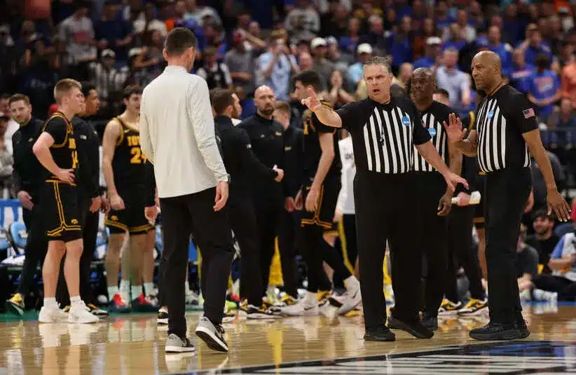 Referees talk to Florida Gators head coach Todd Golden after a fight against the Iowa Hawkeyes
