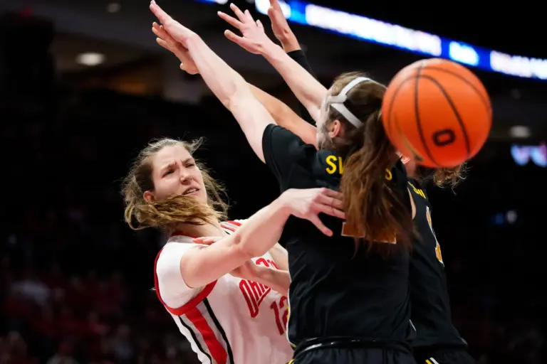 Ohio State Buckeyes center Elsa Lemmilä (12) passes around Michigan Wolverines guard Syla Swords (12) during the NCAA women's basketball game at the Jerome Schottenstein Center on Feb. 25, 2026. Ohio State lost 88-86 in overtime.
