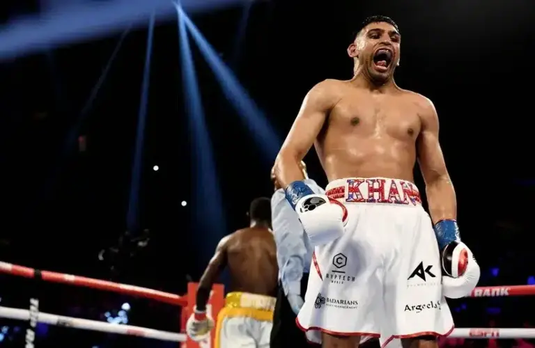 Amir Khan (white trunks) reacts between rounds.