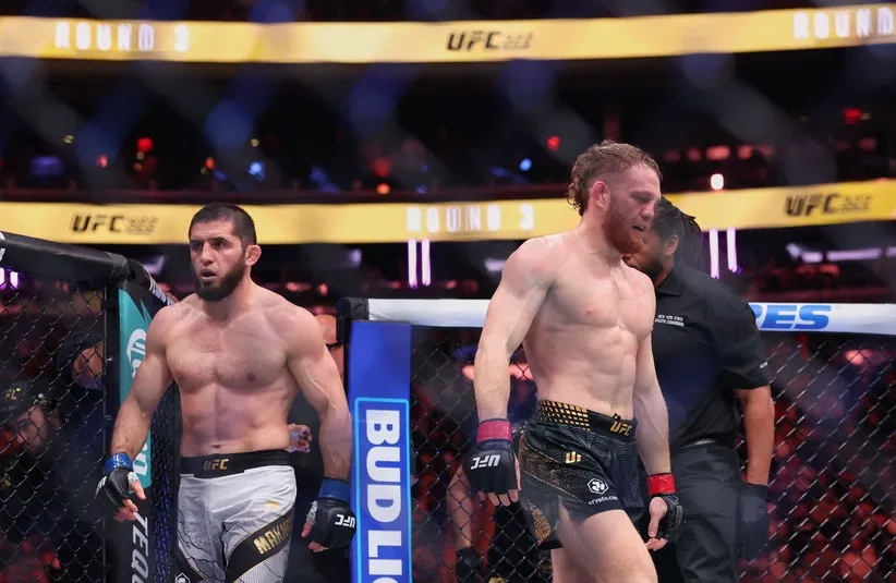 Islam Makhachev (blue gloves) and Jack Della Maddalena (red gloves) walk to their corners.