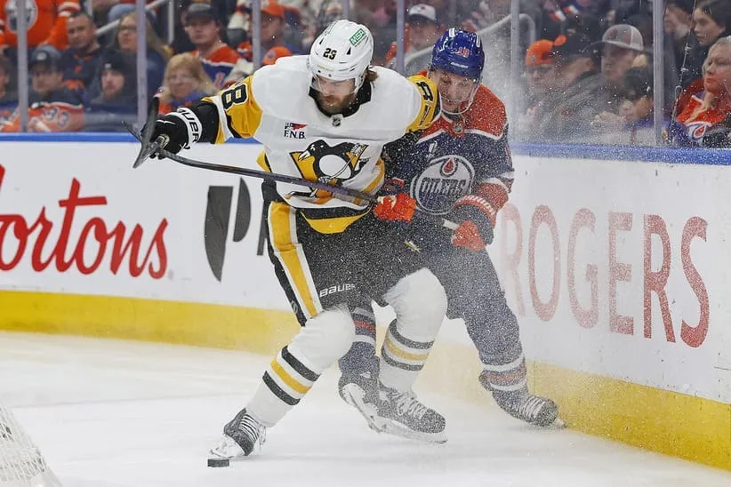 Jan 22, 2026; Edmonton, Alberta, CAN; Pittsburg Penguins defenseman Parker Wotherspoon (28) and Edmonton Oilers forward Zach Hyman (18) battle along the boards for a loose puck during the third period at Rogers Place.