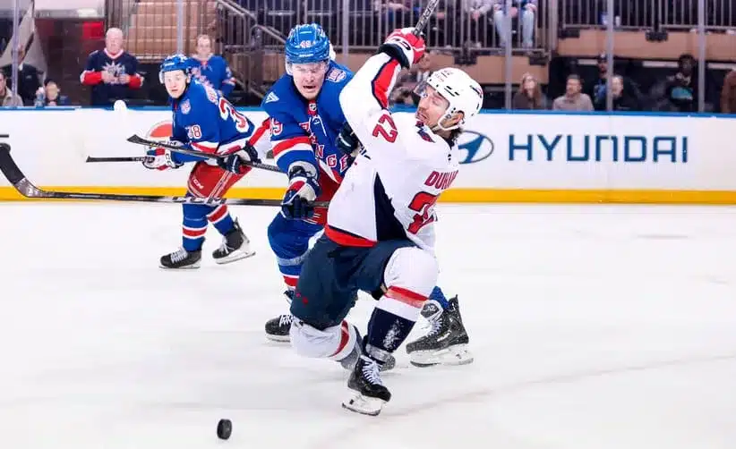 Apr 5, 2026; New York, New York, USA; Washington Capitals left wing Brandon Duhaime (22) is hit by New York Rangers right wing Jaroslav Chmelar (49) during the third period at Madison Square Garden.