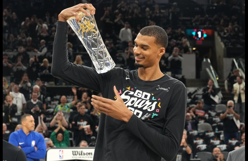 San Antonio Spurs forward Victor Wembanyama (1) holds up his Defensive Player of the Year award before game two of the first round of the 2026 NBA Playoffs against the Portland Trail Blazers at Frost Bank Center.