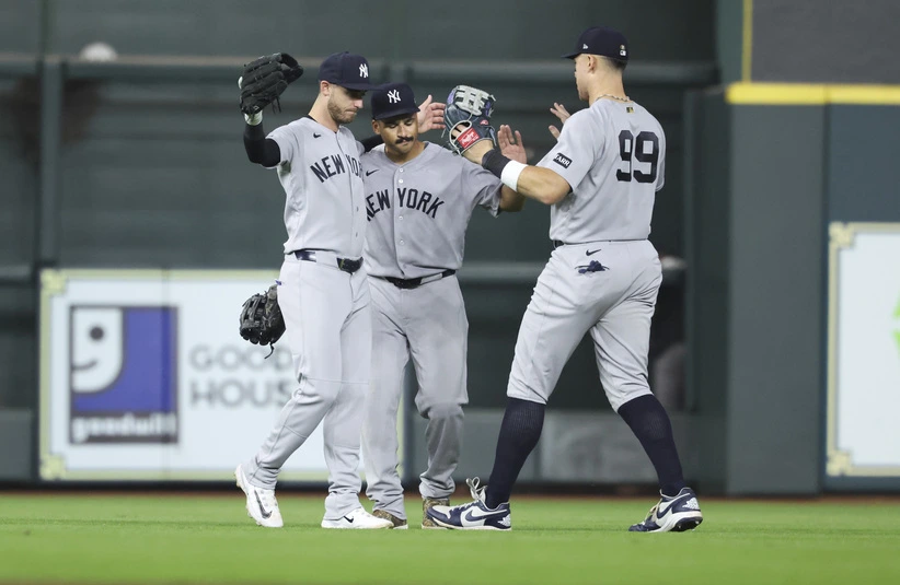 Apr 25, 2026; Houston, Texas, USA; New York Yankees left fielder Cody Bellinger (35) and center fielder Trent Grisham (12) and right fielder Aaron Judge (99) celebrate after the game against the Houston Astros at Daikin Park.
