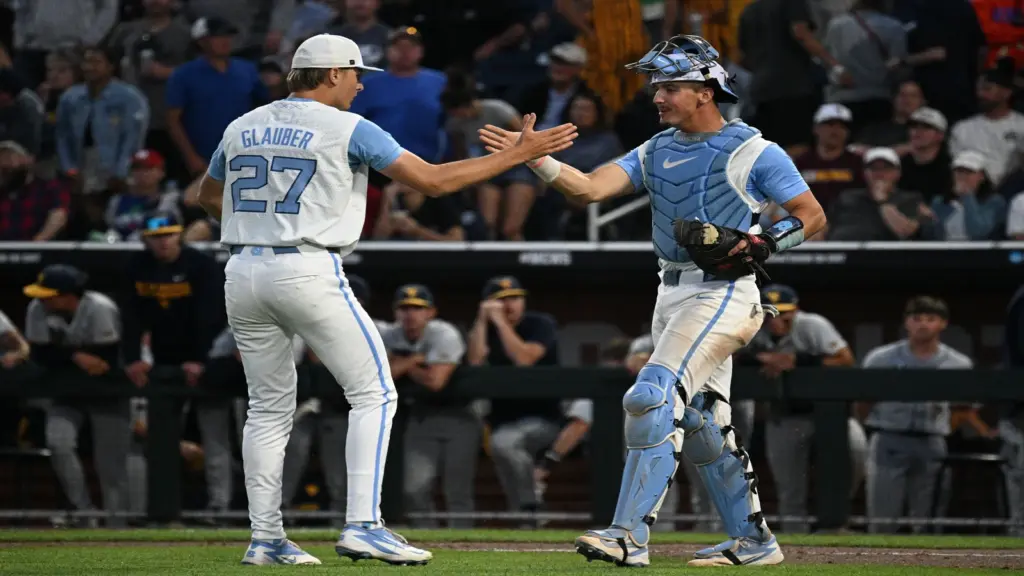 Jun 14, 2026; Omaha, NE, USA; North Carolina Tar Heels pitcher Caden Glauber (27) and catcher Colin Hynek (23) celebrate the win against the West Virginia Mountaineers at Charles Schwab Field in the College World Series.