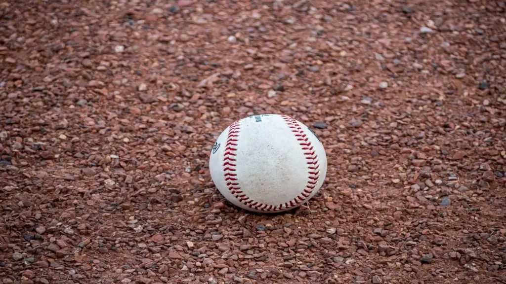 A close-up photograph of a baseball resting on a gravel surface, capturing the texture and detail. This is the instrument of Gerrit Cole's trade with the Yankees.
