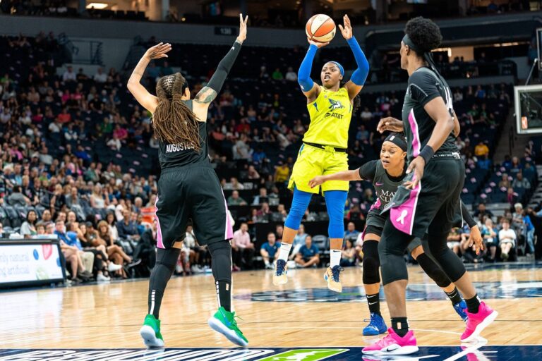 Dallas Wings guard Arike Ogunbowale shoots over Minnesota Lynx defenders in 2019; the Wings beat Valkyries 108-100 behind her 45 points